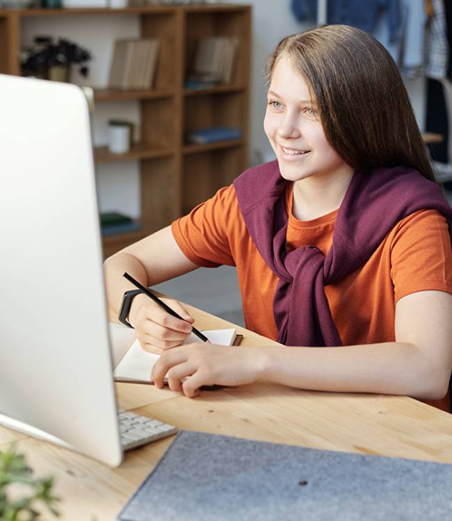 child sitting holding a pen on a book