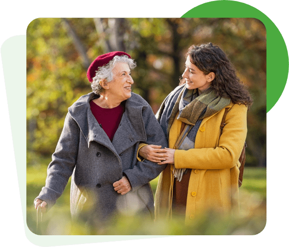 elderly woman walking down the street with her carer